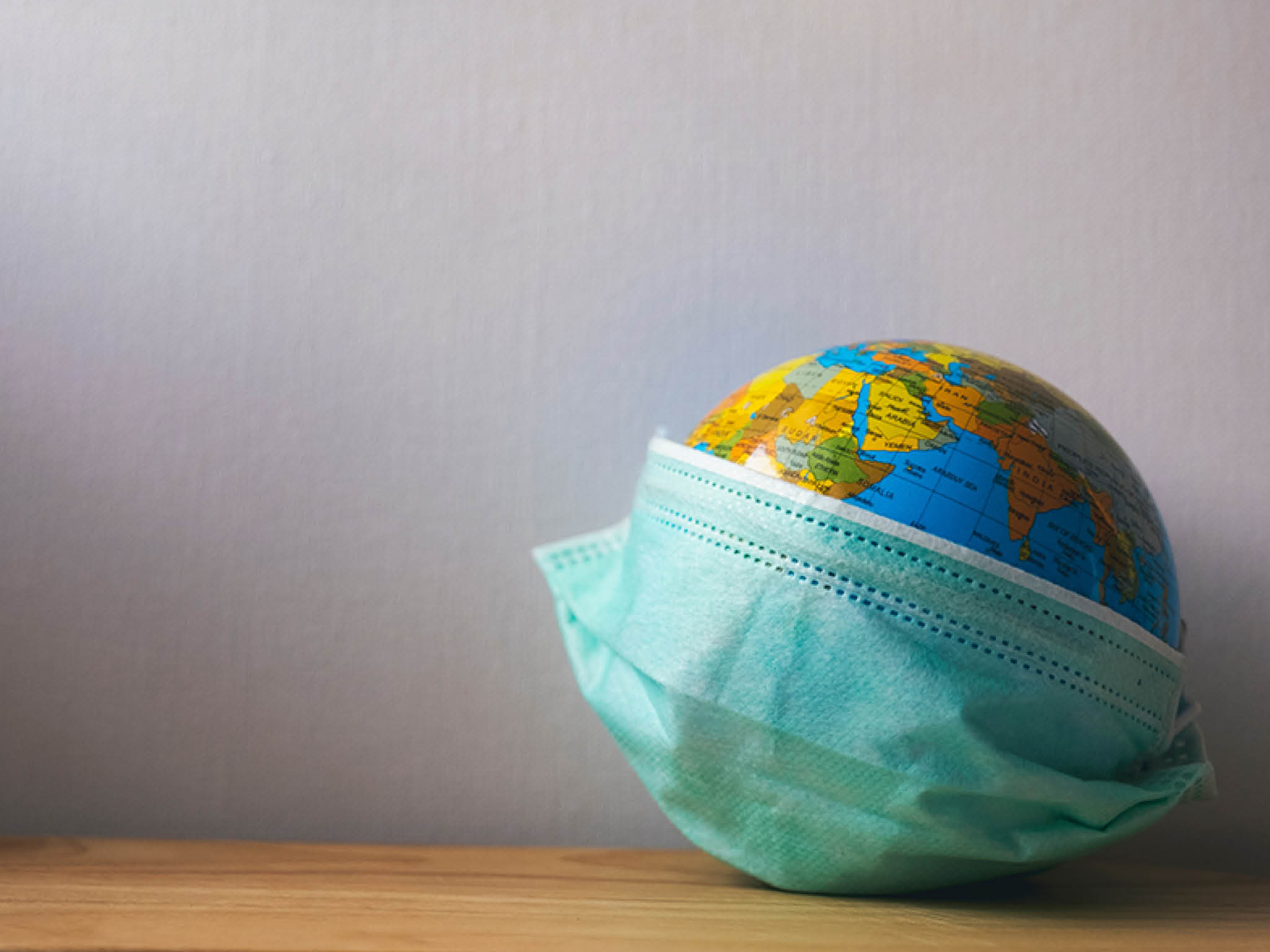 World globus with green medical mask on it. Coronavirus epidemic concept. Concept for world wide spread of Coronavirus desease.