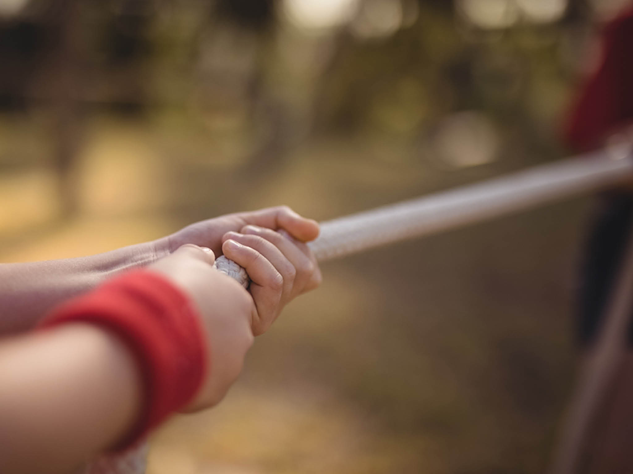 Hands of kid practicing tug of war during obstacle course in boot camp