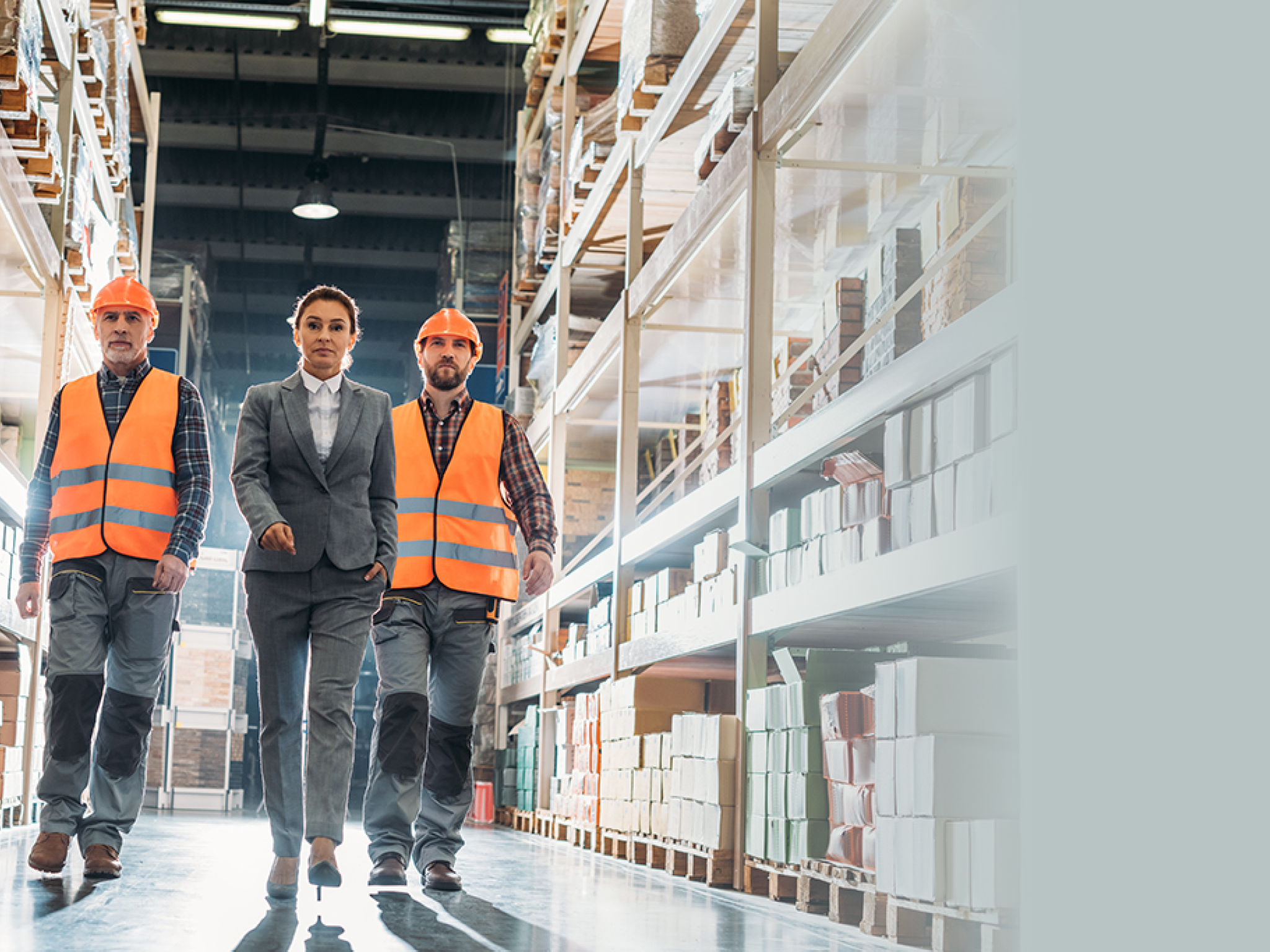workers and inspector going along the corridor in shipping stock