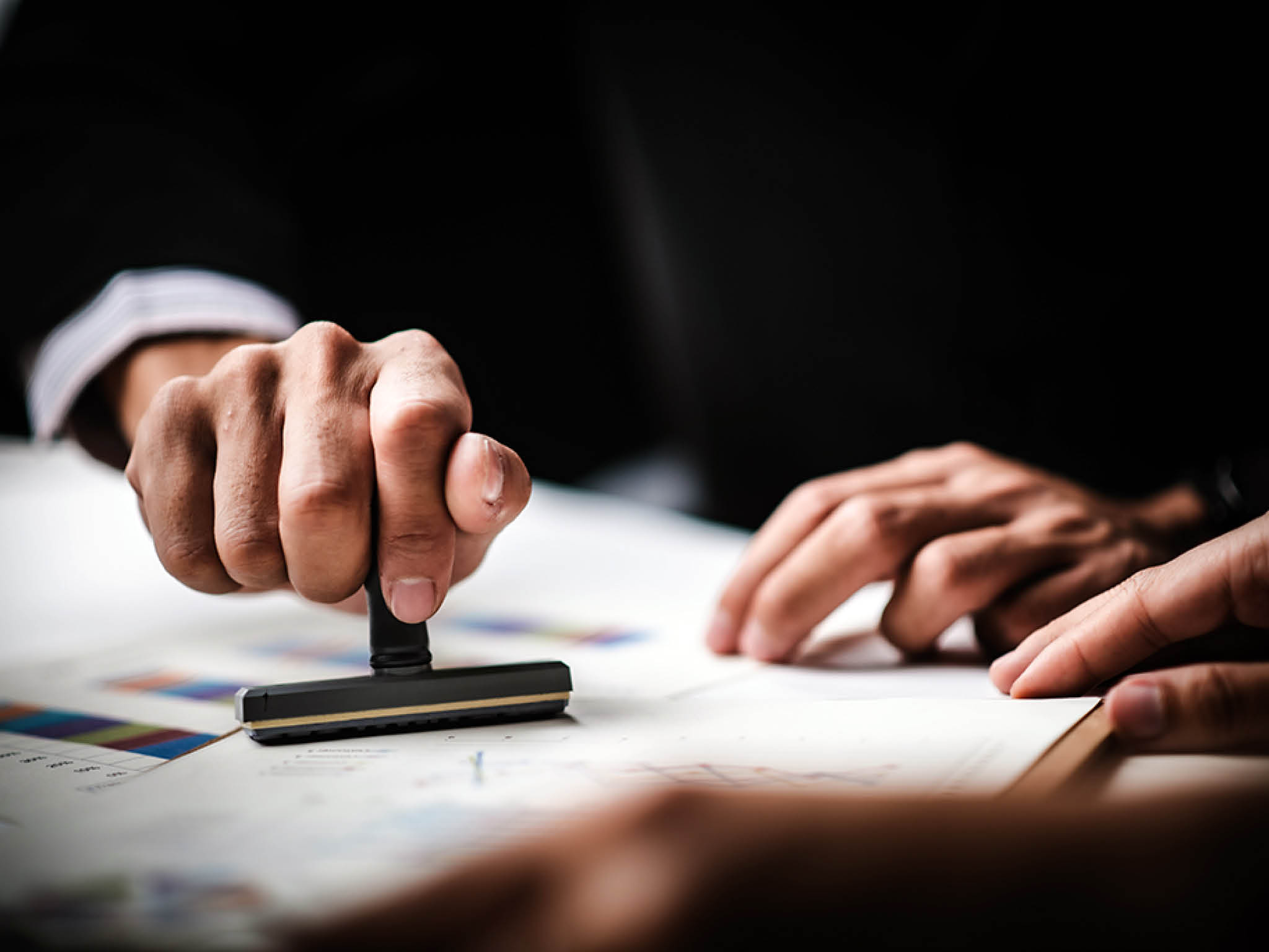 Close-up Of A Person's Hand Stamping With Approved Stamp On Text Approved Document At Desk, Contract Form Paper