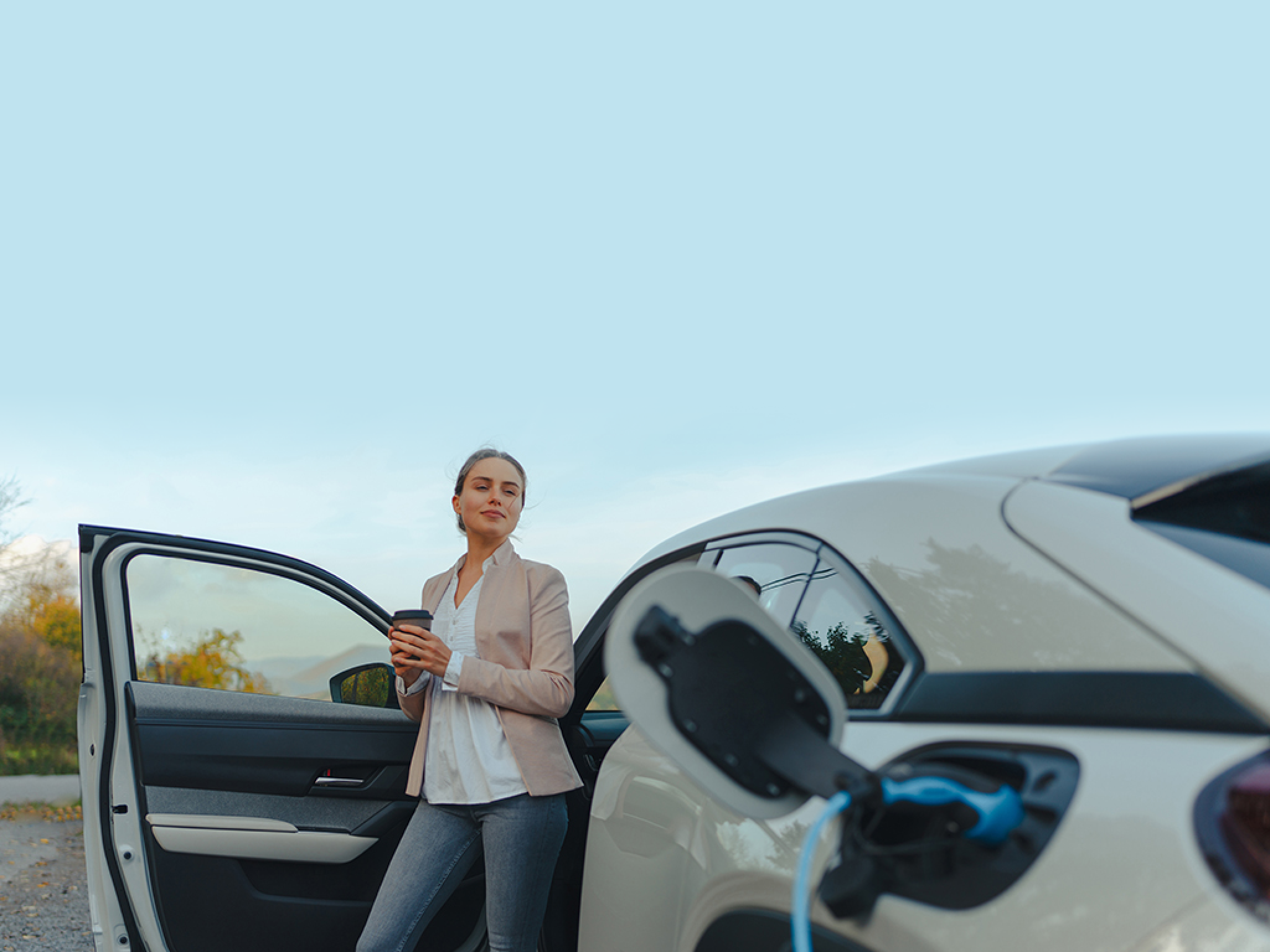 Young woman chargingher car in home, sustainable and economic transportation concept.