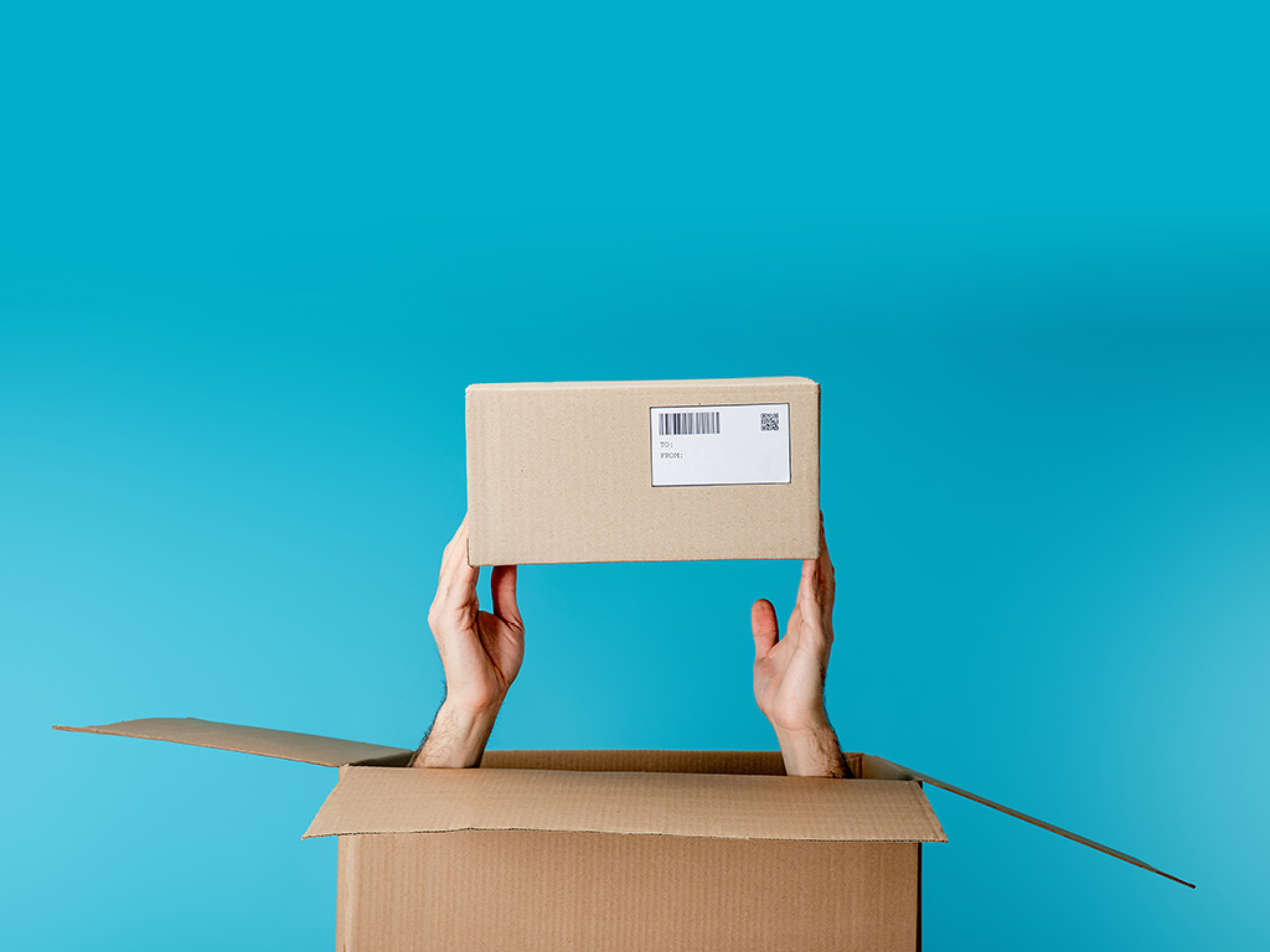 Cropped view of courier holding cardboard box from package isolated on blue